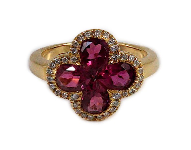 A modern 18k gold four stone pear shaped pink tourmaline set dress ring with diamond chip set border